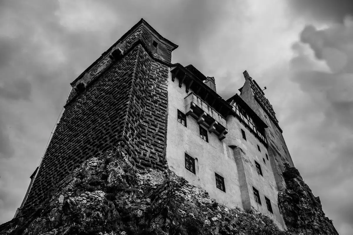Vedere cu un castel istoric cu turnuri din cărămidă roșie și un pod de lemn