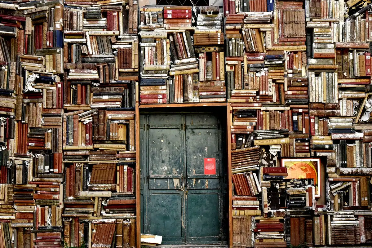 Pereți plini cu cărți și o ușă verde, într-o librărie de vechituri