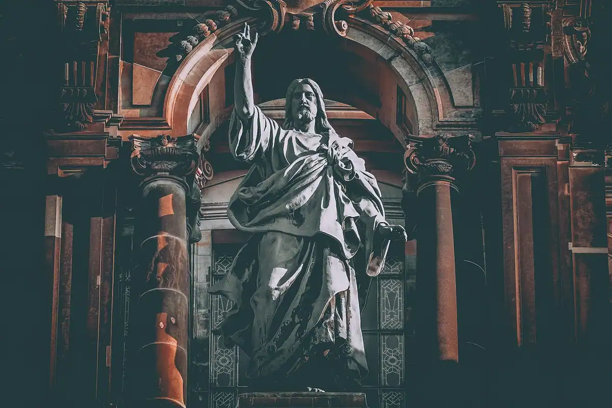 Statuie religioasă de piatră într-o catedrală mare, cu arhitectură impunătoare