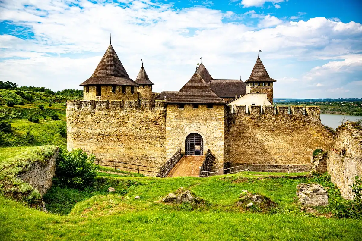 Cetate de piatră pe un mal, înconjurată de natură verde, într-o zi de vară
