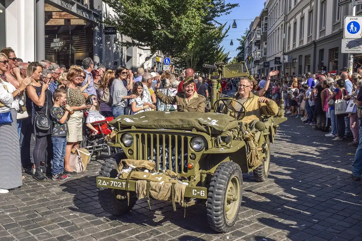 Jeep militar de epocă, înconjurat de oameni, la o paradă istorică