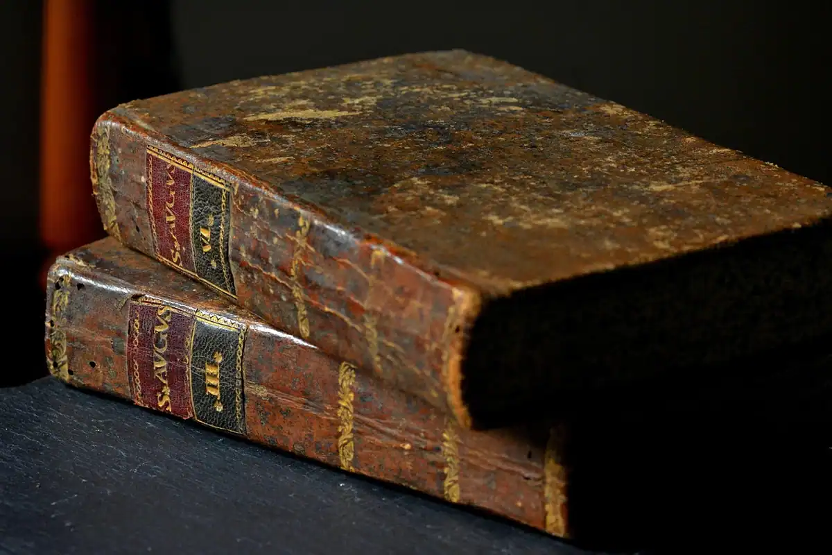 Bibliotecă veche cu cărți așezate pe rafturi și un birou pentru studiu